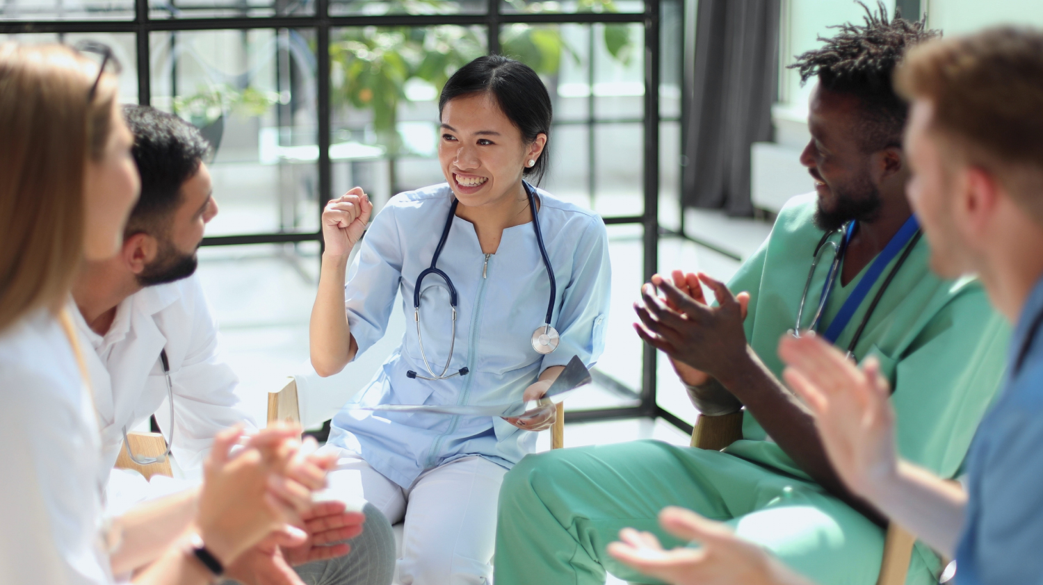 Healthcare Professionals A group of healthcare professionals - nurses, doctors, etc - sat around in a group discussing plans.